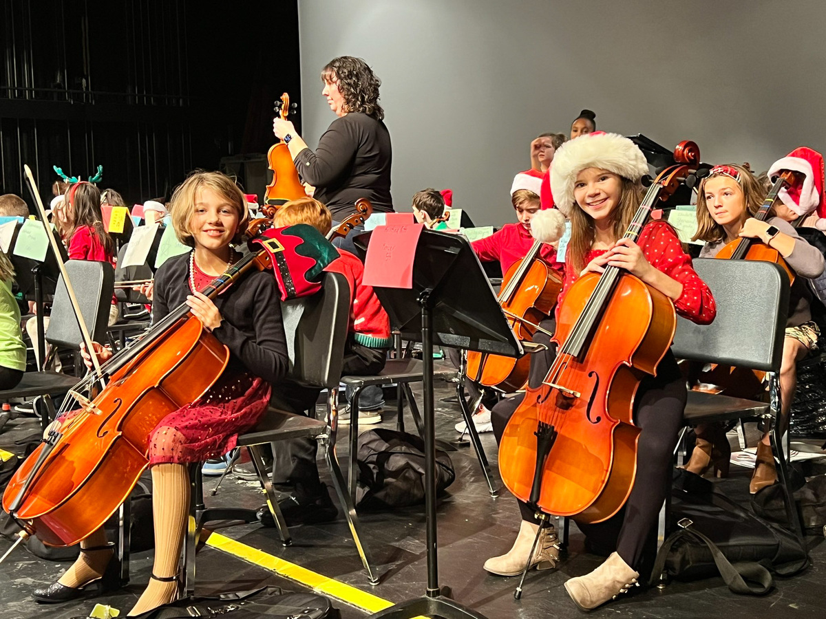 Two orchestra students with cellos